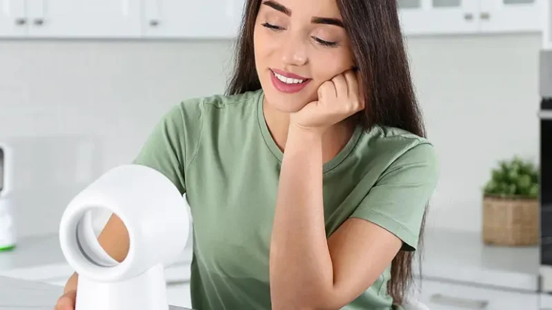 frau sitzt vor ventilator